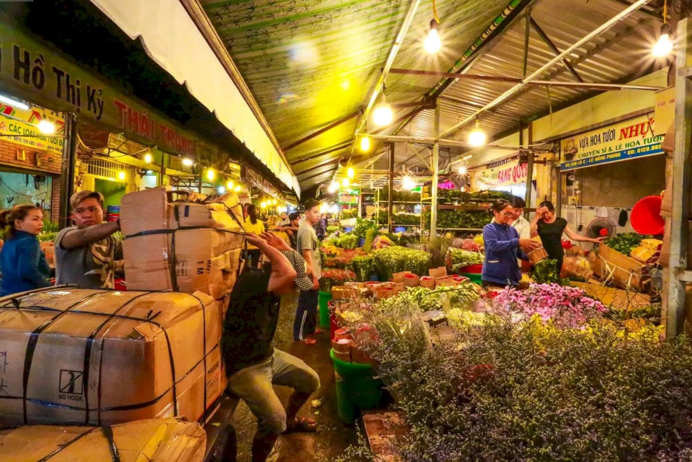 Vendors setting up flower stalls at dawn, preparing for the vibrant rush of the day